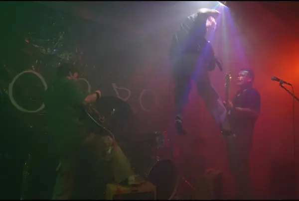 DogPaw guitarist mid-jump at the band's first show, in a basement sports court