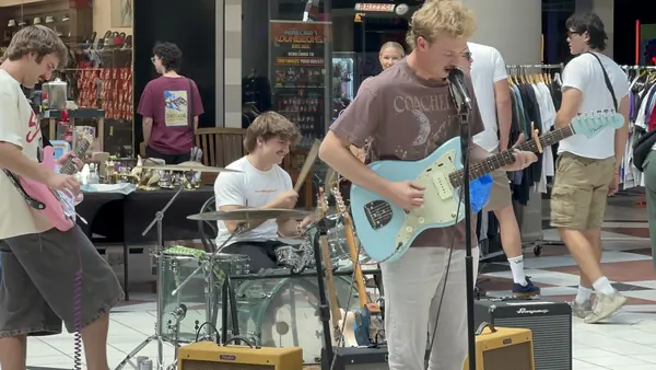 DogPaw guitarist and drummer playing among the market stalls at Provo Towne Centre
