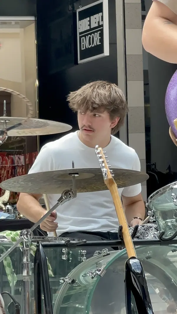 DogPaw drummer behind a clear drum kit at the Provo Farmers Market